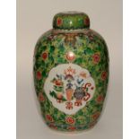 A 19th century Chinese famille verte jar with cover, decorated with panels of precious objects,