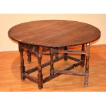 An 18th century country oak gateleg table, with frieze drawer,