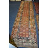An Eastern runner, the central panel with multiple rose motifs over pink ground,
