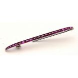 A Cartier white metal and ruby bar brooch, the 21 graduated rubies within channel setting,