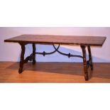 A mahogany refectory table, the rectangular plank top raised on lyre supports with metal stretchers,