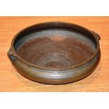 A large antique Chinese style cast bronze basin, of circular form with scroll handles,