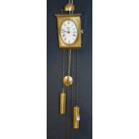 A French brass twin train wall clock by Angelique, the 3½" oval dial with Roman numerals, side door,