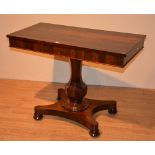 A William IV rosewood side table, with swivel top, above faceted urn shaped column support,