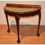 A reproduction walnut demi-lune side table in the style of Chippendale,