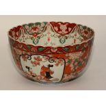 A large Chinese circular porcelain punch bowl, decorated with panels of figures in foliage, red,