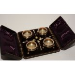 A boxed set of four silver salt cellars with spoons, hallmarks for London 1896-7 RP,