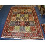 An Arak carpet, with patchwork motif to centre depicting different foliate designs on red, navy,