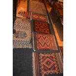 A group of seven small Eastern rugs, saddle bags and prayer mats,