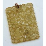 An Oriental jade pendant, the pierced rectangular formation carved with four Oriental gentlemen,