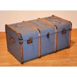 A vintage wood bound travel trunk, with hinged top and carry handles,