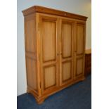 A modern pine veneer triple door wardrobe,