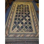 An Eastern rug, the central panel with allover multicoloured diamonds on navy and white ground,