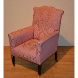 A vintage fireside armchair circa 1920's, upholstered in pink floral fabric,