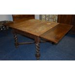 An oak pull out dining table circa 1930's, raised on spiral column supports,