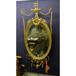 An antique gilt wall mirror, with floral swag and urn decoration,