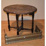 A Jacobean style carved oak occasional table, 66cm high x 80cm wide, also with metal fire fender,