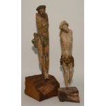 Two painted wooden statues of Christ on the cross, arms lacking, raised on wooden plinth base,
