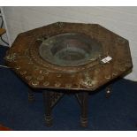 A late 19th century Burmese octagonal table, with hammered insert to the wooden octagonal top,