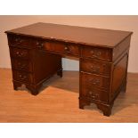 A reproduction kneehole desk, the rectangular top with three drawers,