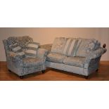 A modern two seater settee with matching armchair, upholstered in pale green floral velour,
