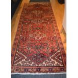 An Eastern rug, with three central white medallions over red ground,