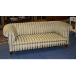 A Victorian Chesterfield sofa, upholstered in period dralon, with rolled arms,