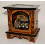 A Victorian walnut music box, with glazed panel to top and door enclosing brass cylinder,