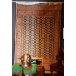 A Bokhara machine made carpet, with all over geometric and floral motifs on blue ground,