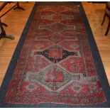 An Eastern runner, decorated with six central medallions on red ground, with geometric border,