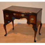 A George III and later mahogany lowboy, with serpentine top,