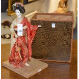 A vintage geisha doll on stand, with porcelain head, hands and feet, human hair to head,