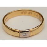An 18ct gold and diamond wedding band, with brilliant cut diamond mounted in square of white gold,