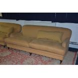 A large modern two seater sofa, upholstered in yellow fabric,