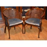 A pair of vintage bergere tub style armchairs, raised on cabriole supports with pad foot,