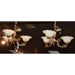 A pair of Victorian style three branch ceiling lights, each with three frilly glass shades,