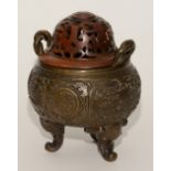 A Chinese cast bronze censor, with pierced wooden cover, decorated with panels of Chinese symbols,