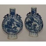 A pair of Chinese blue and white moon shaped vases, with grotesque finials,