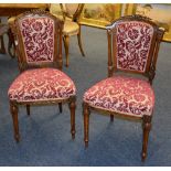A pair of Victorian walnut parlour chairs, upholstered in later red floral fabric,