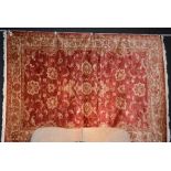 A machine made Ziegler carpet, with allover gold floral motifs on red ground,