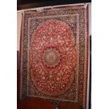 A machine made Keshan carpet, the central flowerhead medallion over red ground,