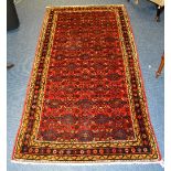 A Hamadan rug, with allover geometric designs over red ground, with black and mustard triple border,