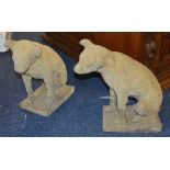 A pair of composite stone dog figures, raised on plinths,