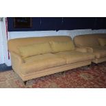 A large modern two seater sofa, upholstered in yellow fabric,