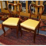 A set of four Victorian walnut dining chairs, with shaped open tops above carved rail,