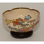 A Japanese Satsuma bowl on carved wood stand, decorated with floral panels, 21.