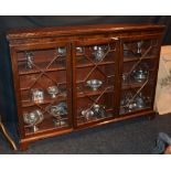 A mahogany three door glazed bookcase, the three glazed astragal doors enclosing shelved interior,