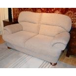 A modern two seater sofa, upholstered in beige fabric, 100cm high,