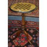 A Victorian walnut games table, the circular top having inlaid chess board,
