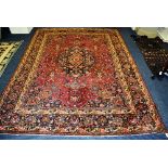 A Meshed carpet, the central foliate medallion over dark pink ground,